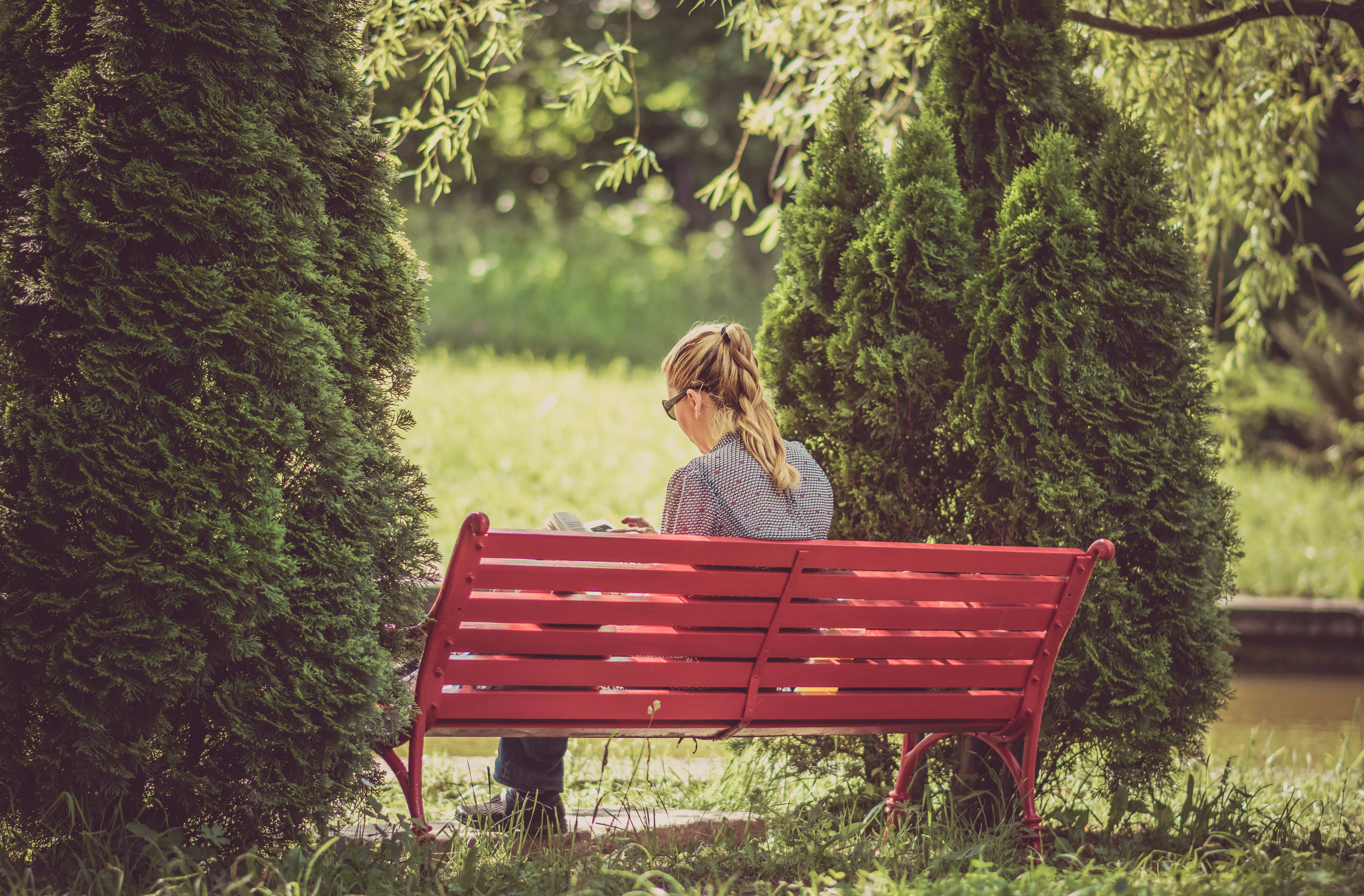 woman sitting on red wooden bench